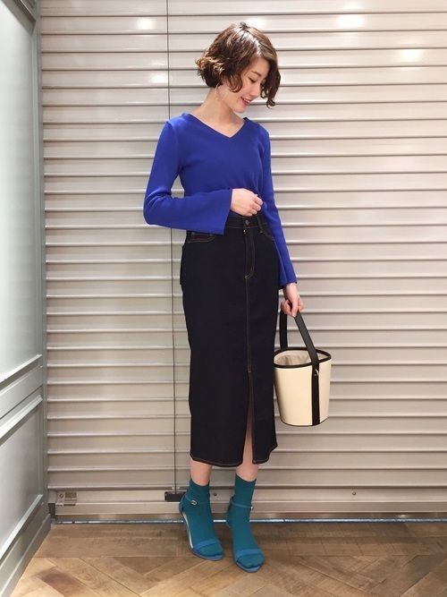 クリーム色の優しいイメージのシンプルなサロペットに、アクセントとなる赤の靴下とパンプスを合わせたコーデ。サロペットのてろんとした素材感がレディ感をきかせて